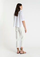 Chemise blanche femme coton Isabella, vue de profil, col boutonné, manches courtes, silhouette élégante et intemporelle