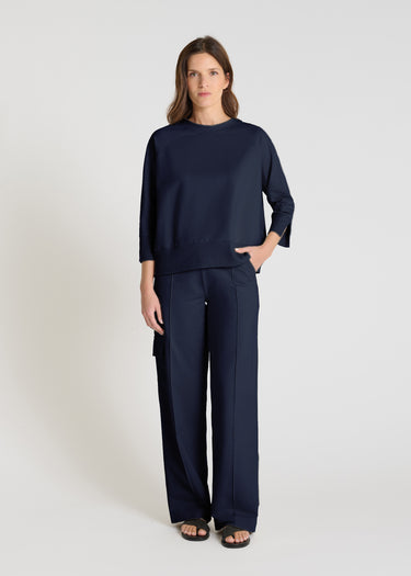 Pull sans manches femme bleu nuit en maille de coton, encolure V, porté avec pantalon beige - Vue de face Tournesol
