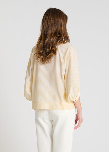 Détail chemisier femme rayé jaune, manches longues avec bracelet boutonné, blouse chic coton graphique
