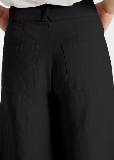 Détail jupe-culotte Zafar noire en lin, texture armurée, fermeture zip et bouton corozo naturel
